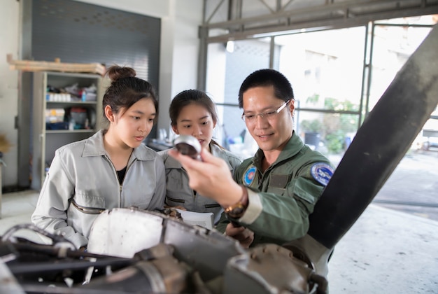 Aziatische mannen en vrouwen Ingenieurs en technici repareren vliegtuigen