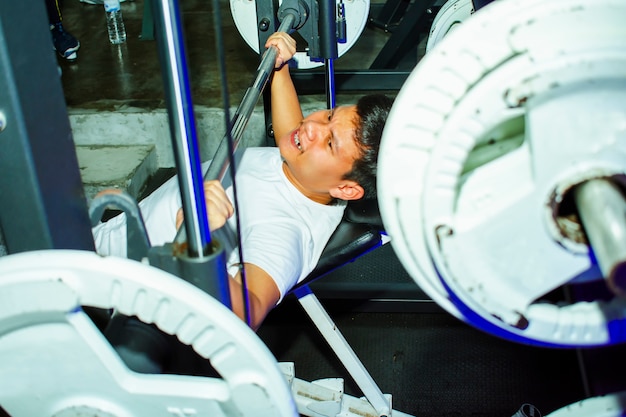 Aziatische mannen oefenen borsttraining op bankdrukken machine levensstijl van de mens voor fitness