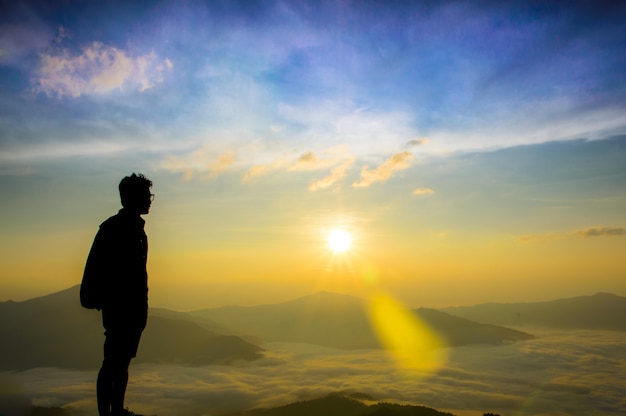 Aziatische mannen staan te kijken naar de mist en de zonsopgang.