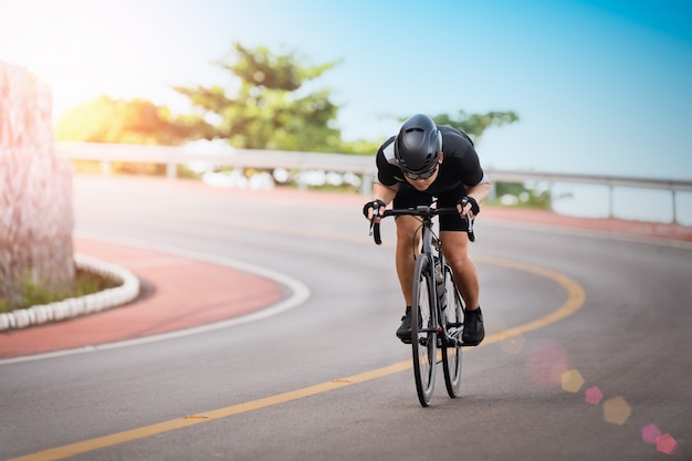 Aziatische mens die de openluchtwegen van de oefeningsfiets in de ochtend cirkelen.