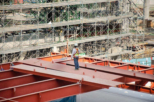 Aziatische mensen en Thaise arbeiders met zware machines werken bouwer nieuw gebouw op bouwplaats hoogbouw gebouw op steiger in hoofdstad in Bangkok Thailand