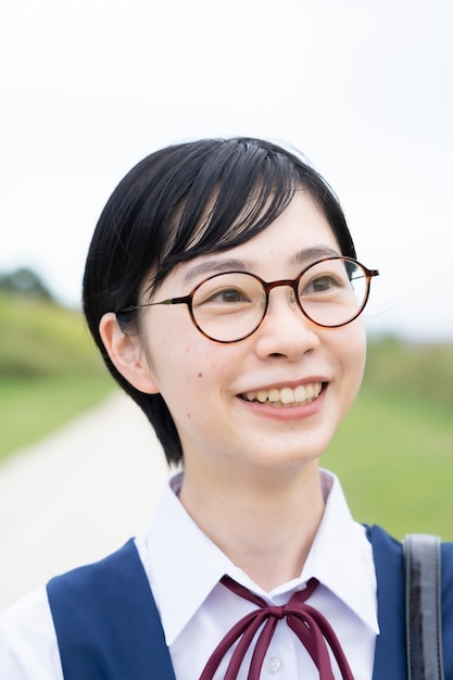 Aziatische middelbare schoolmeisjes die uniformen dragen en op school glimlachen