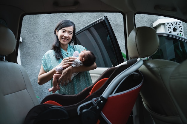 Aziatische moeder glimlach bij het dragen van haar dochtertje