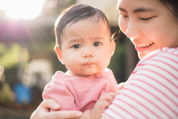 Aziatische moeder houdt dochter in armen Ze hield haar dochter in haar omhelzing Gelukkig Aziatisch familiekind en moeder wandelen in de natuur Gelukkige moederdag