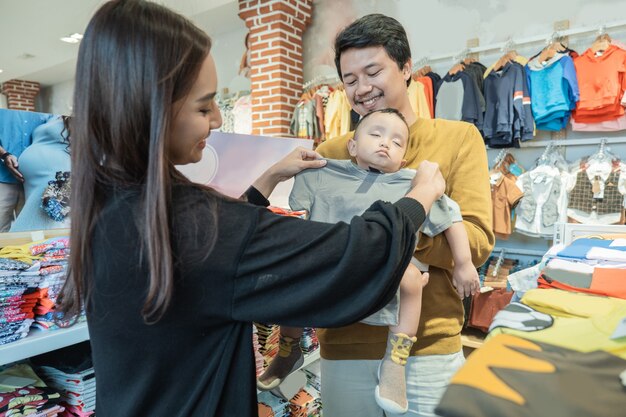 Aziatische moeder met haar peuterjongen die in de babywinkel winkelt