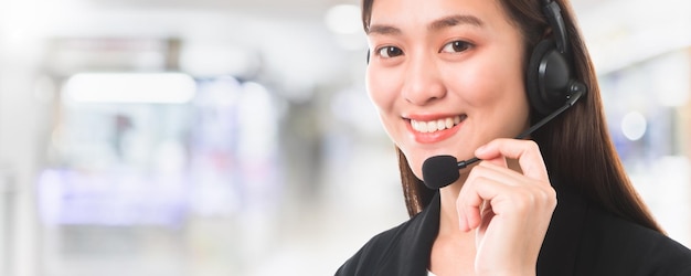 Aziatische mooie glimlachende vrouw klantenservice telefoon operator in kantoor interieur ruimte achtergrond en kopieer spaceConcept call center job service