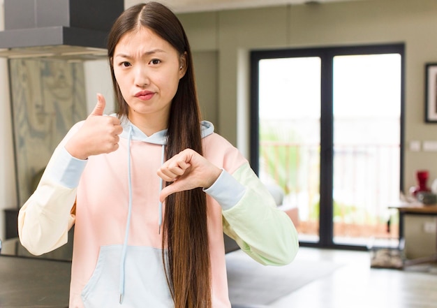 Aziatische mooie vrouw bij nieuw huis die een idee uitdrukt