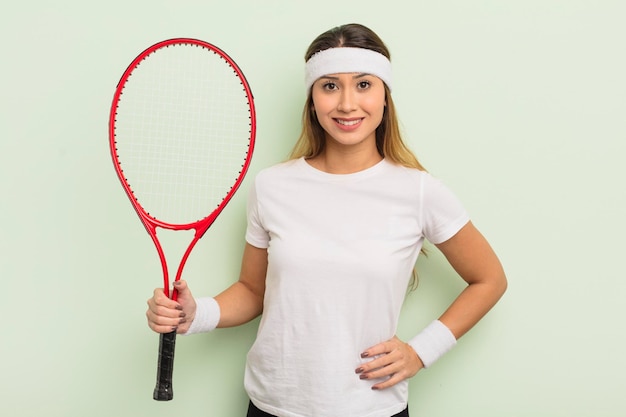 Aziatische mooie vrouw die gelukkig lacht met een hand op de heup en zelfverzekerd. tennisconcept