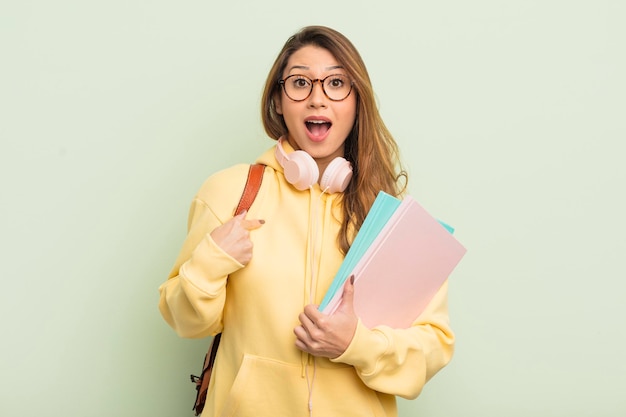 Aziatische mooie vrouw die geschokt en verrast kijkt met de mond wijd open wijzend naar het concept van de zelfuniversitaire student