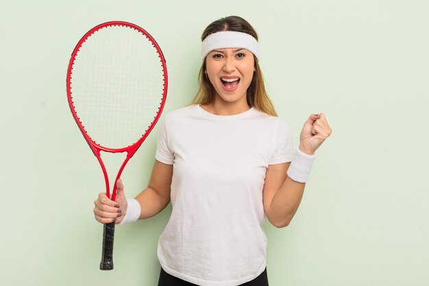 Aziatische mooie vrouw die geschokt is, lacht en viert succes tennisconcept