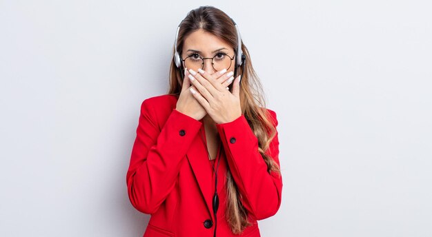 Aziatische mooie vrouw die mond bedekt met handen met een geschokt. telemarker concept