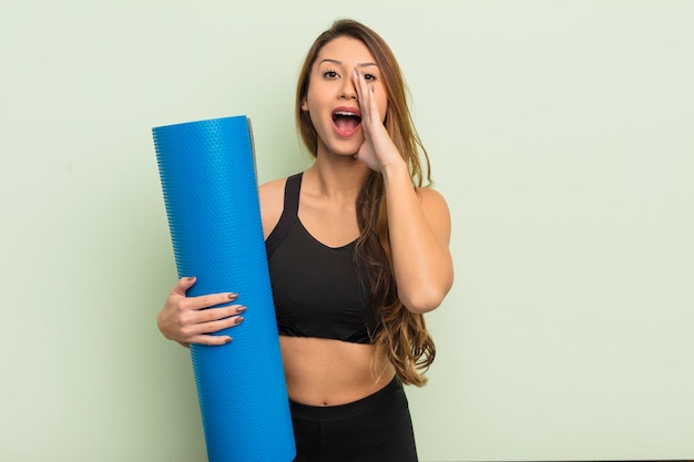 aziatische mooie vrouw die zich gelukkig voelt, een grote schreeuw geeft met de handen naast de mond. yoga concept