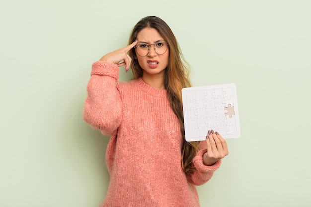 Aziatische mooie vrouw die zich verward en verbaasd voelt en laat zien dat je een krankzinnig puzzelconcept bent