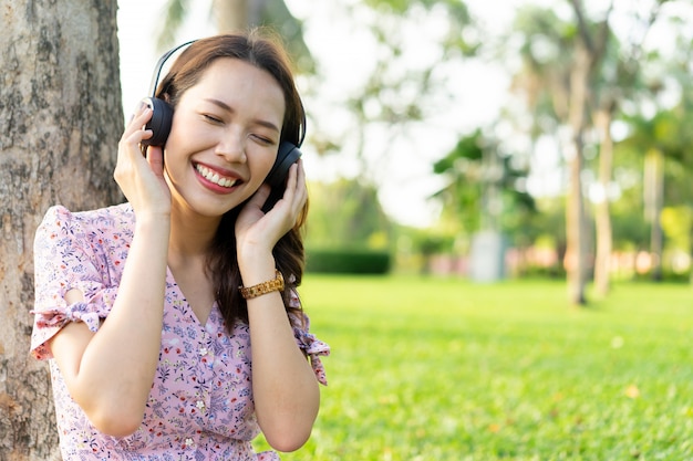 Aziatische mooie vrouw luisteren muziek in het park