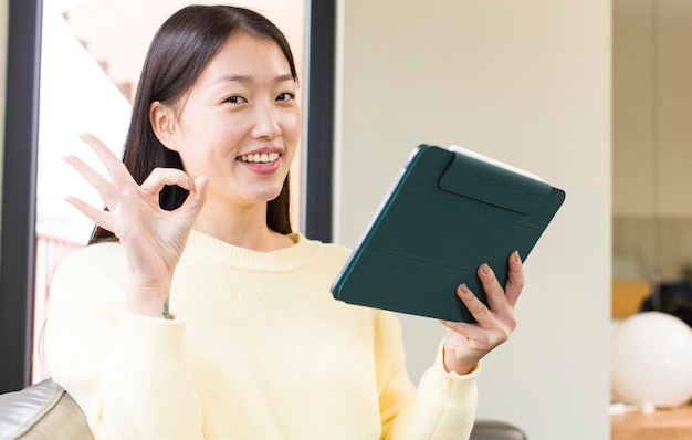 Aziatische mooie vrouw met behulp van een touchscreen-pad