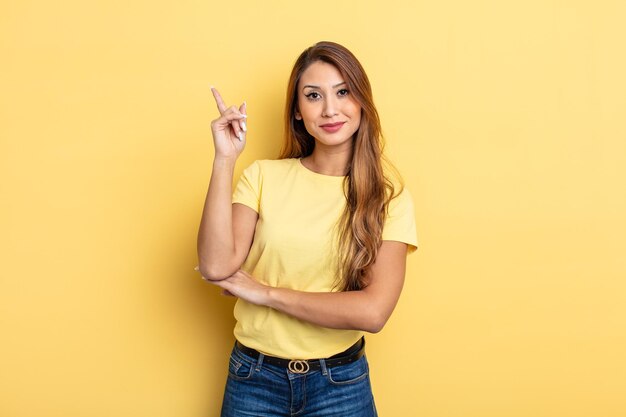 Aziatische mooie vrouw voelt zich een genie die haar vinger trots in de lucht houdt nadat ze een geweldig idee heeft gerealiseerd en eureka zegt