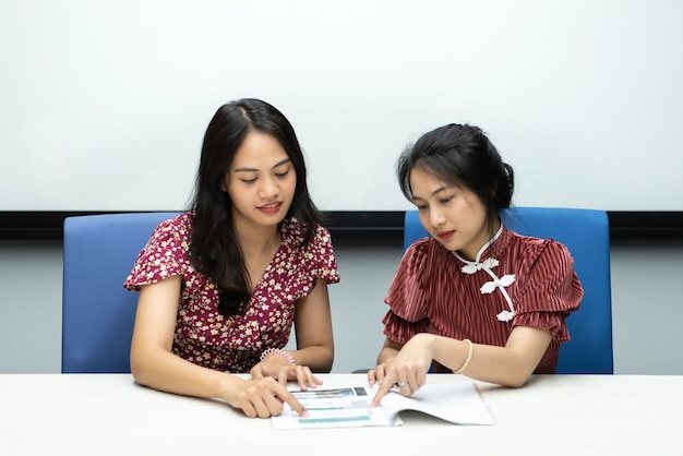 Aziatische mooie vrouwen in cheongsam chinese stijl grote gelukkige vreugdevolle en collega discussie in vergaderruimte op kantoor met blij en glimlach in concept succes, winnaar, succesvol of zakelijk