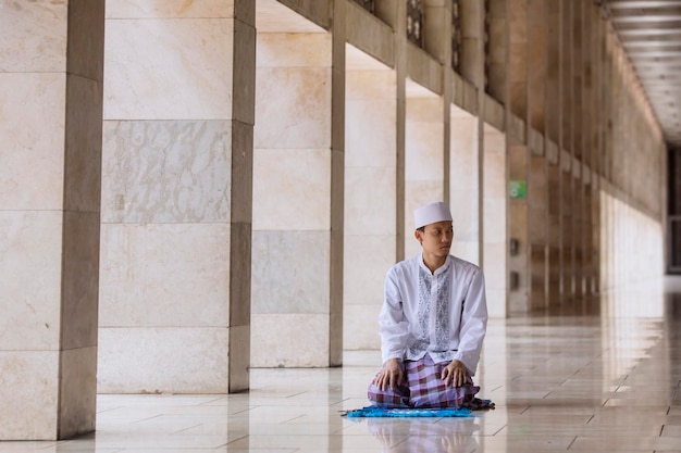 Aziatische moslim man doet Salat op de moskee