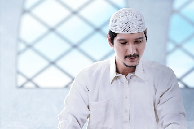 Aziatische moslim man zit in de moskee