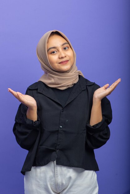 Aziatische moslimvrouw met aantrekkelijk gebaar op paarse achtergrond