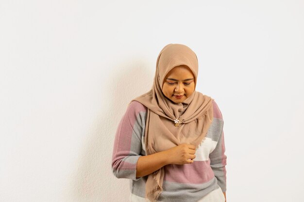 Foto aziatische moslimvrouw met een hijab of hoofddoek die naar beneden kijkt indonesische vrouw op witte achtergrond