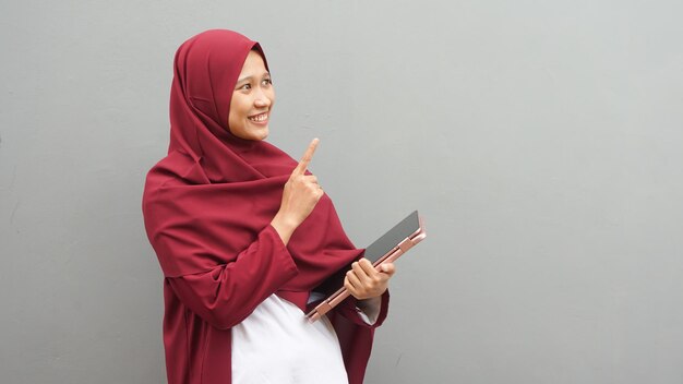 Aziatische moslimvrouw met notitieboekje. leraar beroep