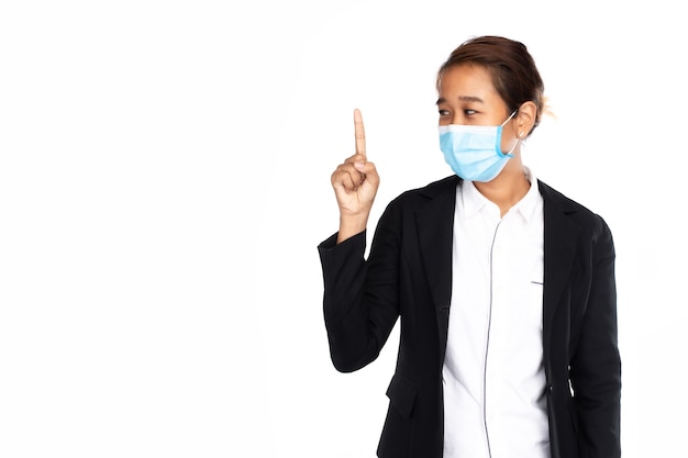 Aziatische onderneemster die chirurgisch gezichtsmasker in formeel zwart kostuumjasje draagt, wijzende vinger