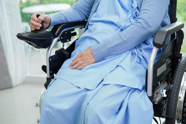 Aziatische oudere vrouw handicap patiënt zittend op elektrische rolstoel in park medisch concept