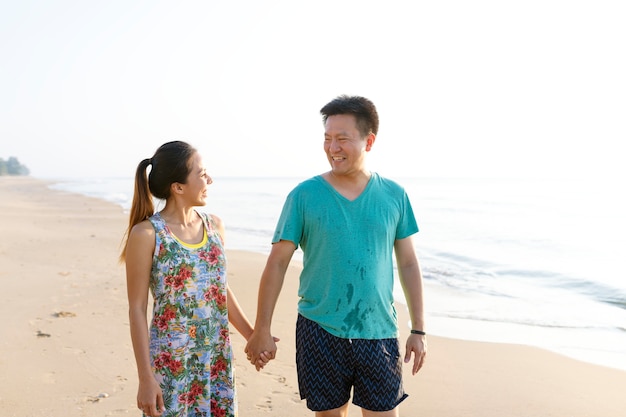 Aziatische paar hand in hand aan het strand