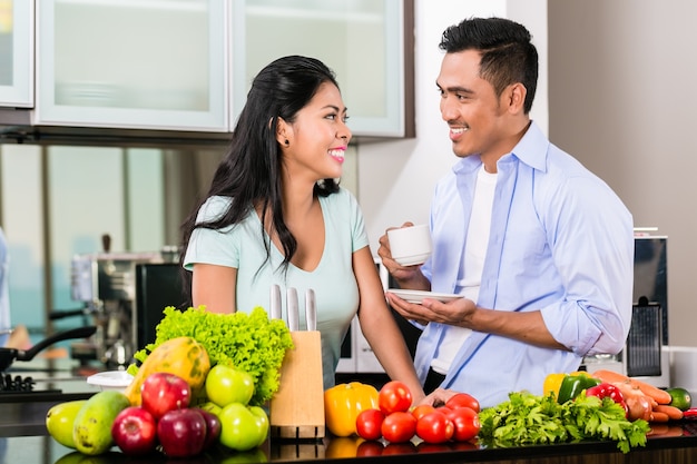 Aziatische paar, man en vrouw, samen koken van voedsel in de keuken en koffie maken