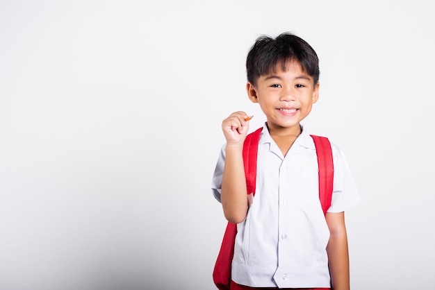 Aziatische peuter glimlachend gelukkig dragen student thai uniform rode broek met potlood voor schrijvers notebook