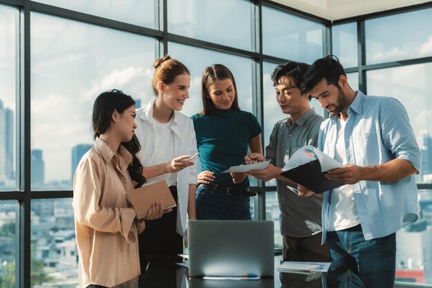 Aziatische projectmanager gebruikt een laptop met getoonde data-analyse terwijl een professioneel zakelijk team brainstormt over een marketingidee tijdens een zakelijke vergadering Samenwerken idee delen plannen strategie Tracery