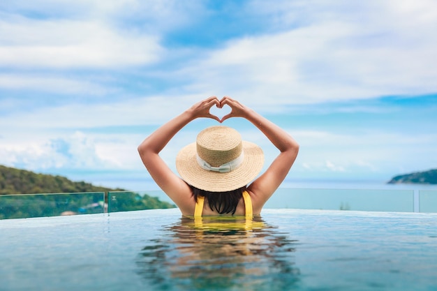 Foto aziatische reizen bikini vrouw ontspannen in infinity pool resort op phuket beach thailand