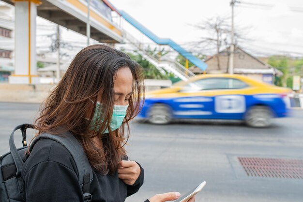 Aziatische reizigersvrouw draagt een masker ter bescherming van het coronavirusThaise vrouw draagt een gezichtsmasker met ademhalingsbescherming en filtert PM25-deeltjes