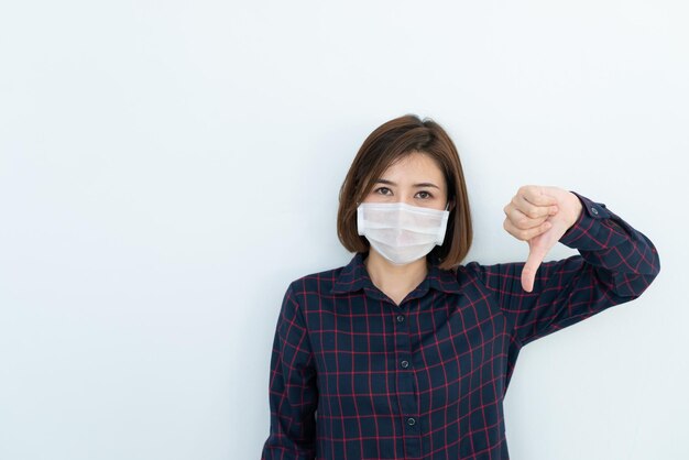 Aziatische reizigersvrouw draagt een masker ter bescherming van het coronavirusThaise vrouw draagt een gezichtsmasker met ademhalingsbescherming en filtert PM25-deeltjes