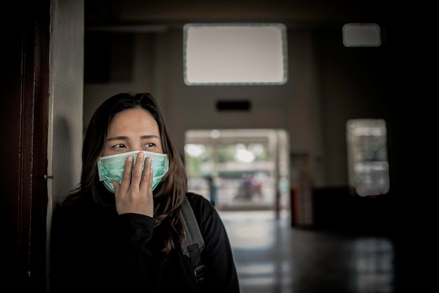 Aziatische reizigersvrouw draagt een masker ter bescherming van het coronavirusThaise vrouw draagt een gezichtsmasker met ademhalingsbescherming en filtert PM25-deeltjes