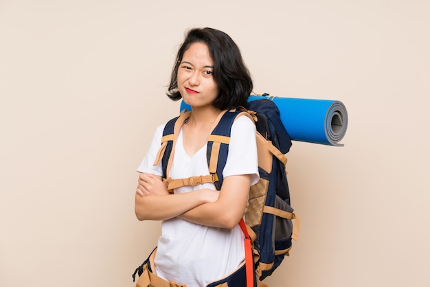 Aziatische reizigersvrouw over geïsoleerd makend twijfelsgebaar terwijl het opheffen van de schouders