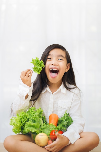 Aziatische schattig meisje eet verse salade