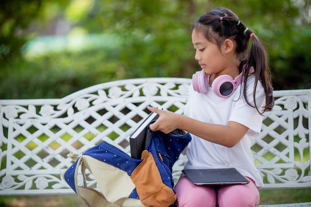 Aziatische schattige basisschoolmeisjes die hun schooltassen inpakken en zich voorbereiden op de eerste schooldag