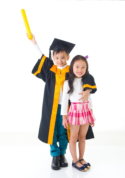 Aziatische school kind afgestudeerd in afstuderen jurk en pet. foto maken met zus en broer.