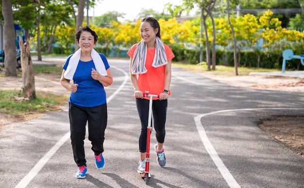 Aziatische senior moeder en tiener dochter grappig met oefening joggen in het park