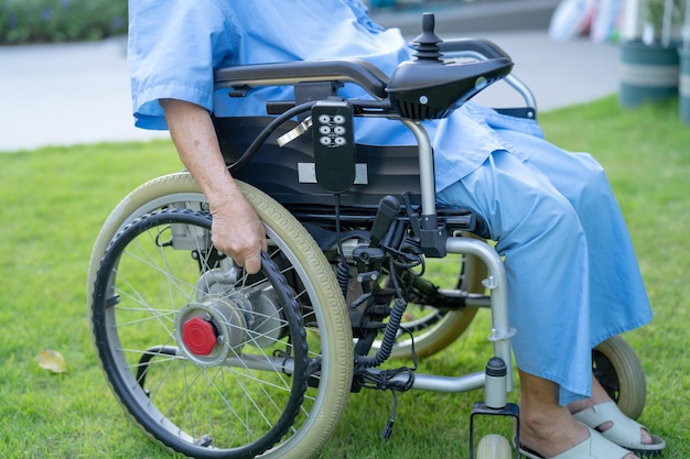 Aziatische senior of oudere oude dame vrouw patiënt op elektrische rolstoel met afstandsbediening op verpleegafdeling gezond sterk medisch concept