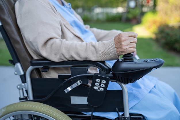 Aziatische senior of oudere oude dame vrouw patiënt op elektrische rolstoel met afstandsbediening op verpleegafdeling gezond sterk medisch concept