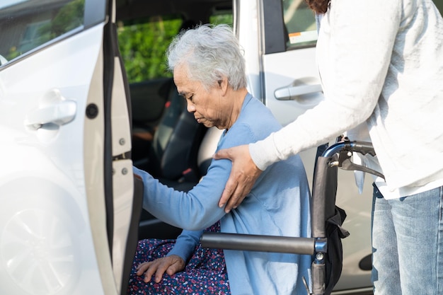 Aziatische senior of oudere oude dame vrouw patiënt zittend op rolstoel voorbereiden om naar haar auto gezond sterk medisch concept te gaan