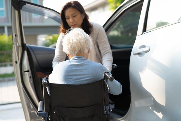 Aziatische senior of oudere oude dame vrouw patiënt zittend op rolstoel voorbereiden om naar haar auto gezond sterk medisch concept te gaan