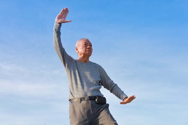 Aziatische Senior oude man praktijk Taichi Chinese Kungfu op het strand