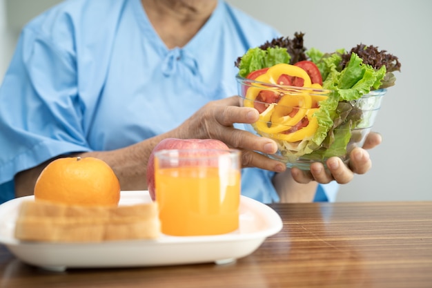 Aziatische senior vrouw patiënt eten ontbijt groente gezond voedsel