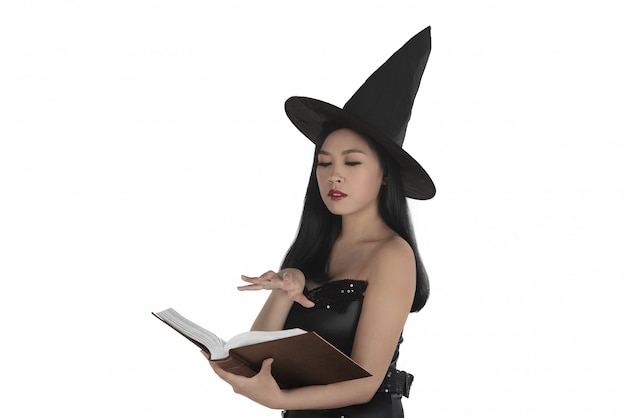 Foto aziatische sexy heks die een betovering creërt bij het boek