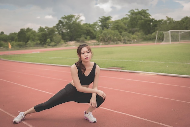 Aziatische slanke vrouw warmt op voordat ze gaat trainen in een ochtendslanke meisjesoefening voor het levenselectieve focusvul fel zonlichtThailand mensen