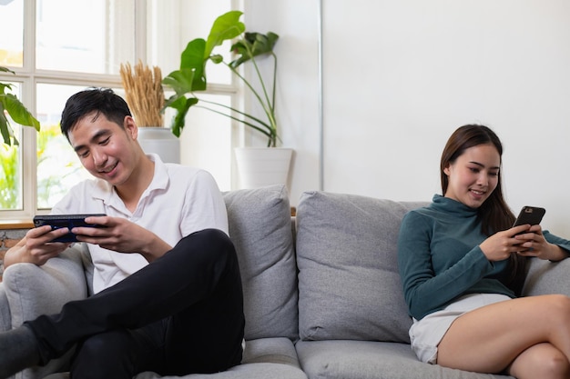 Aziatische stellen zitten onverschillig tegenover elkaar aan de telefoon